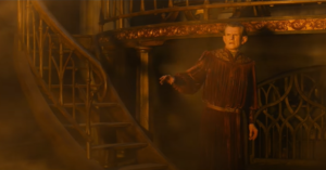 Charles Edwards as Celebrimbor, wearing a dark red velvet gown, walking down an ornate flight of steps into a room of his forge, filled with smoke and a hazy golden light.