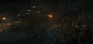 Wide-shot of Eregion at night. The city, which sits on the shores of a wide dark river, is under attack from armies encamped in the forests on the opposite shore, who have set up catapults and trebuchets, and are launching a volley of flaming missiles into the city. A long narrow bridge stands over the river.