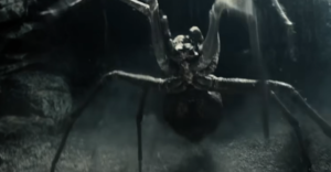 Shelob, a monstrous spider, rears up on its hind legs and lunges forward.