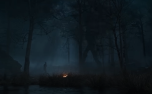 Wide shot of a silhouetted figure standing in a forest at night, looking up at an Entwife, a humanoid tree walking with long, slow steps and swinging branch-like arms.