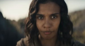 Out-of-focus close-up image of Madeleine Madden as Egwene al'Vere. She has short dark brown hair.