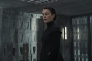 Olivia Williams in Dune: Prophecy. She has dark hair pulled back in a low bun and wears a long-sleeved black dress.